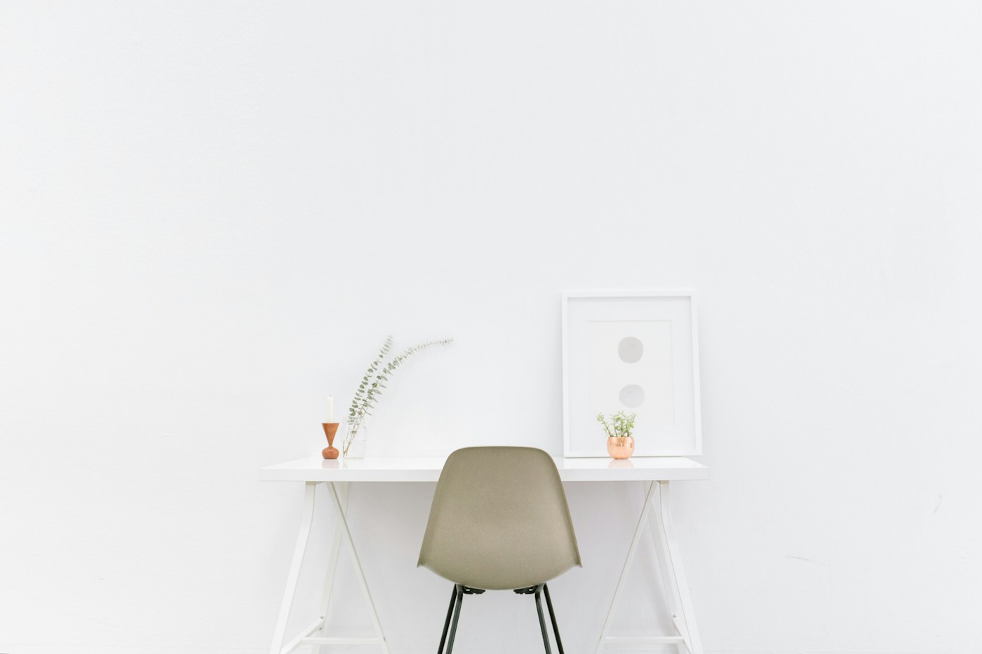 Simple desk and chair against a bright white wall