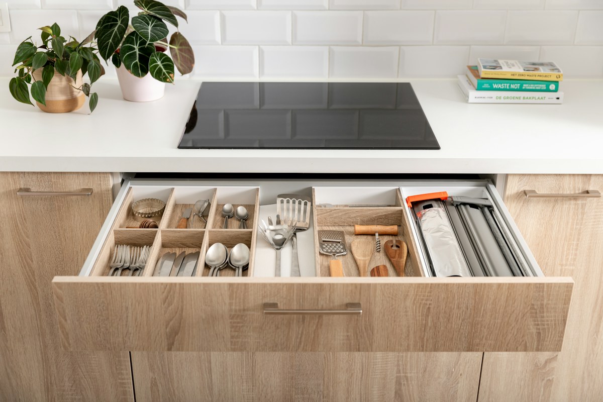 An open kitchen drawer with neatly divided utensils