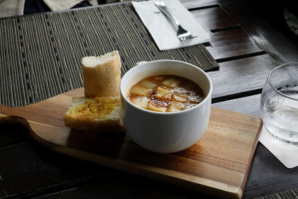 Bowl of soup with bread on a wooden board