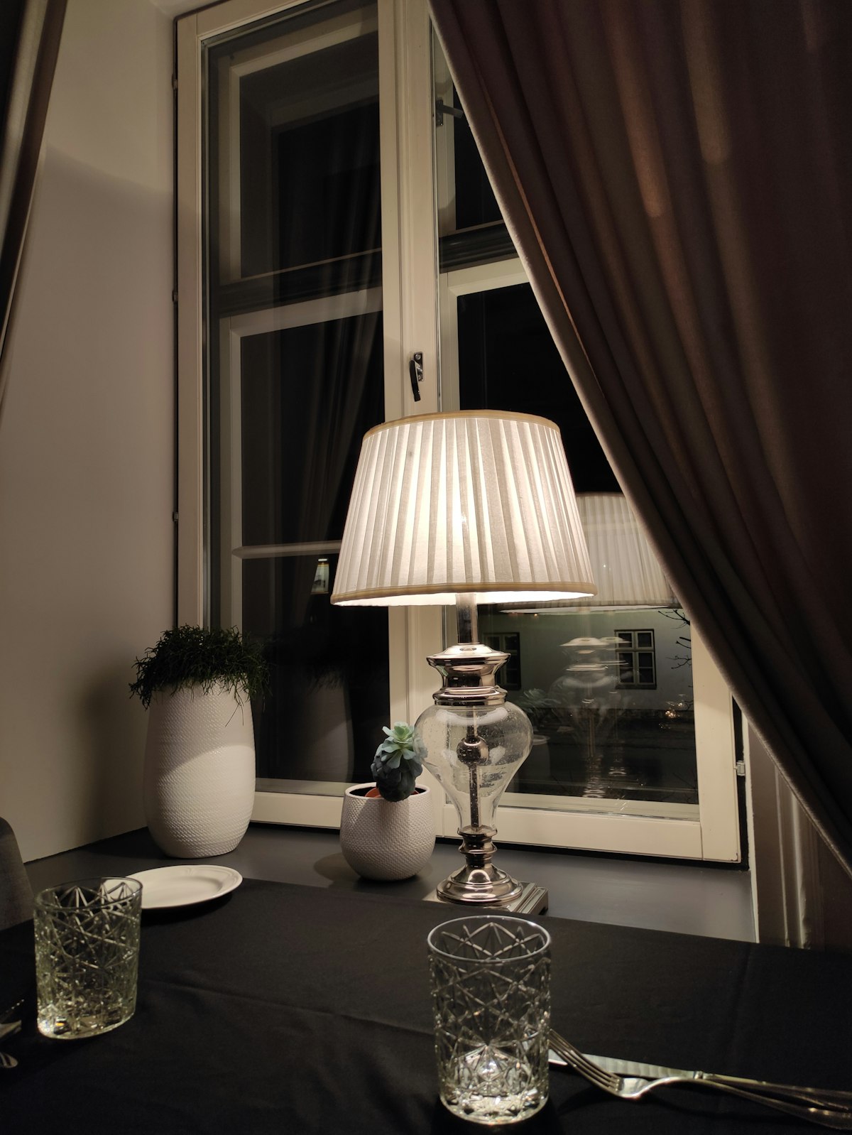 Elegant table lamp illuminating a dinner setting by a window