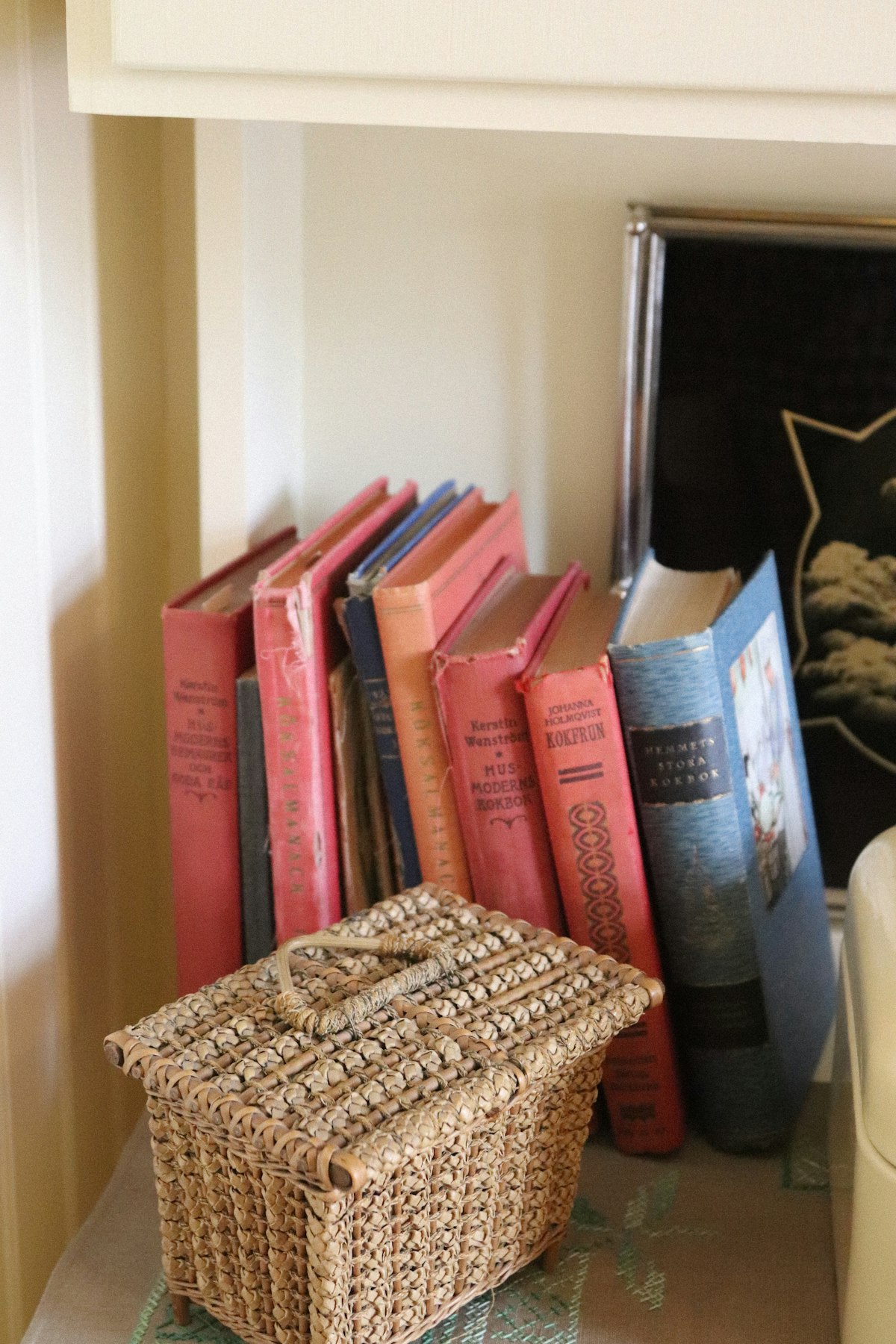 Books and a woven basket sit on a shelf.