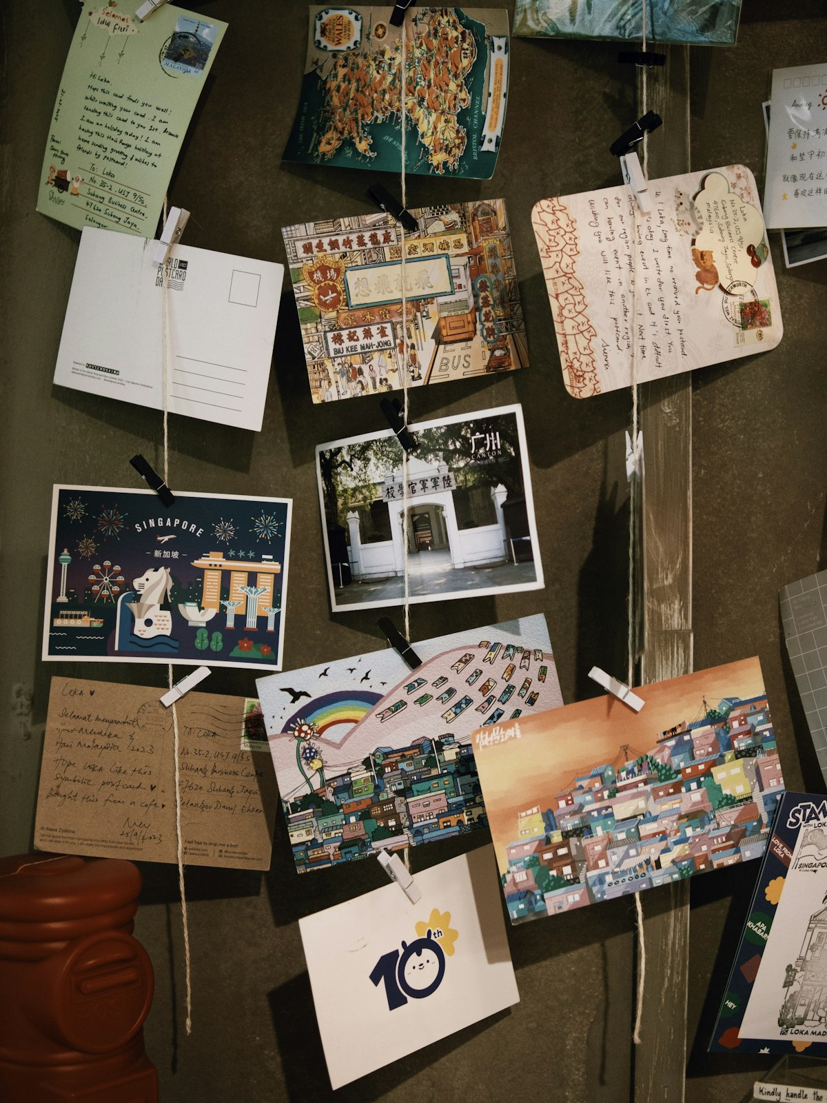 Collection of postcards and letters displayed on a wall