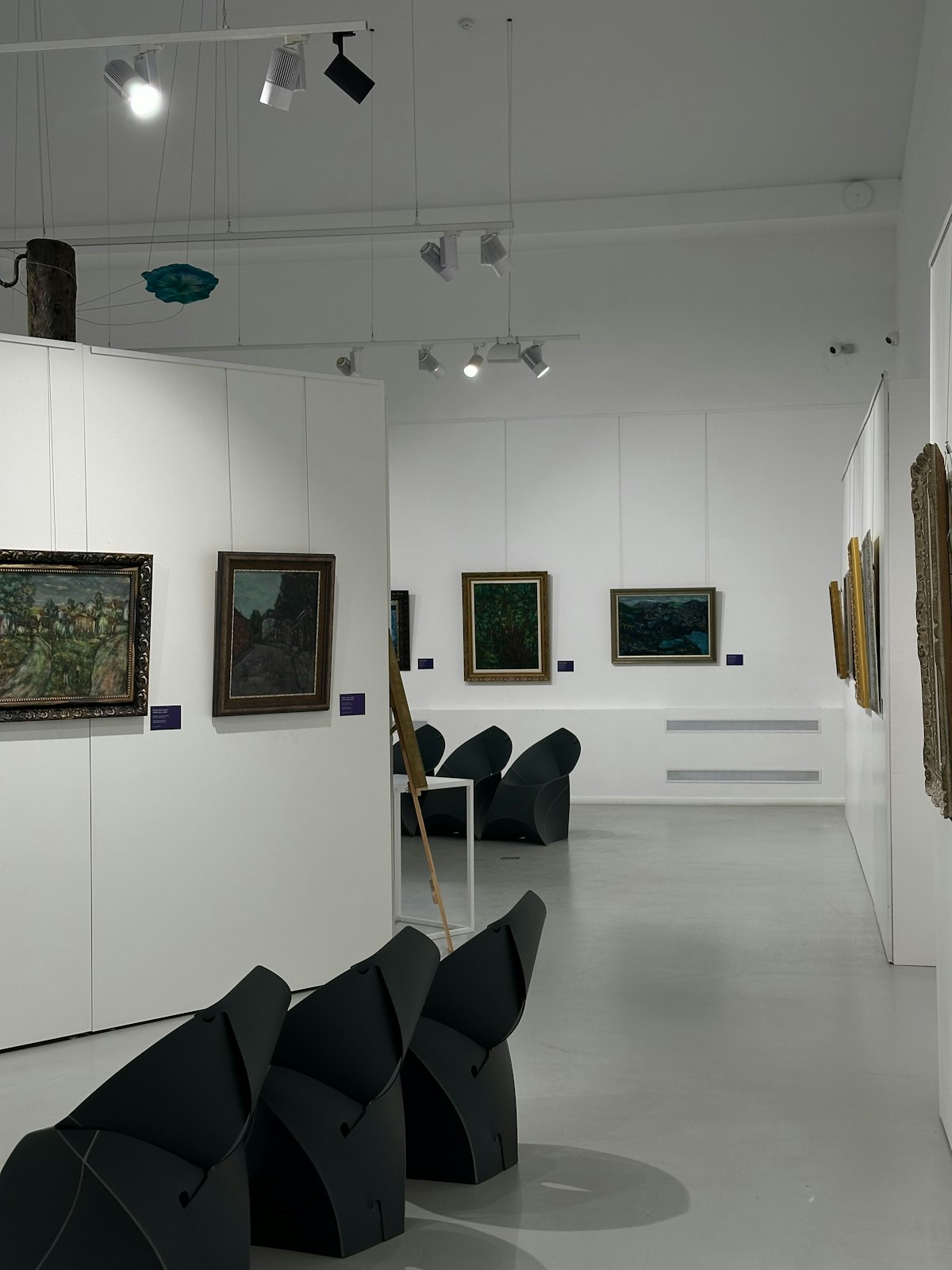 Art gallery interior with paintings and seating