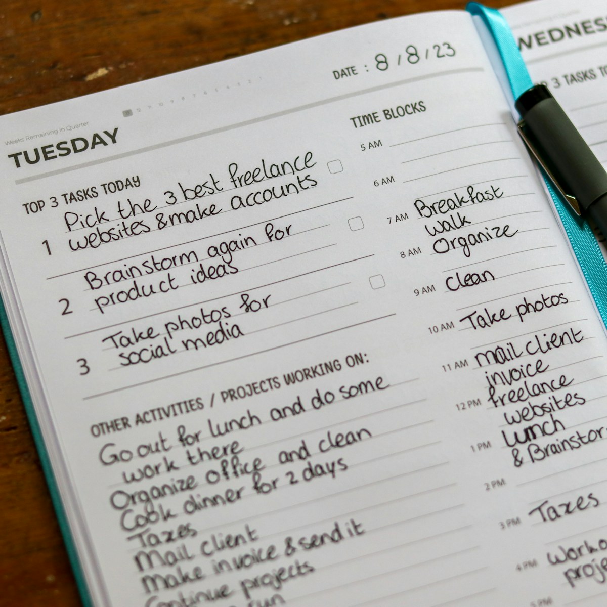 An open planning notebook with a pen
