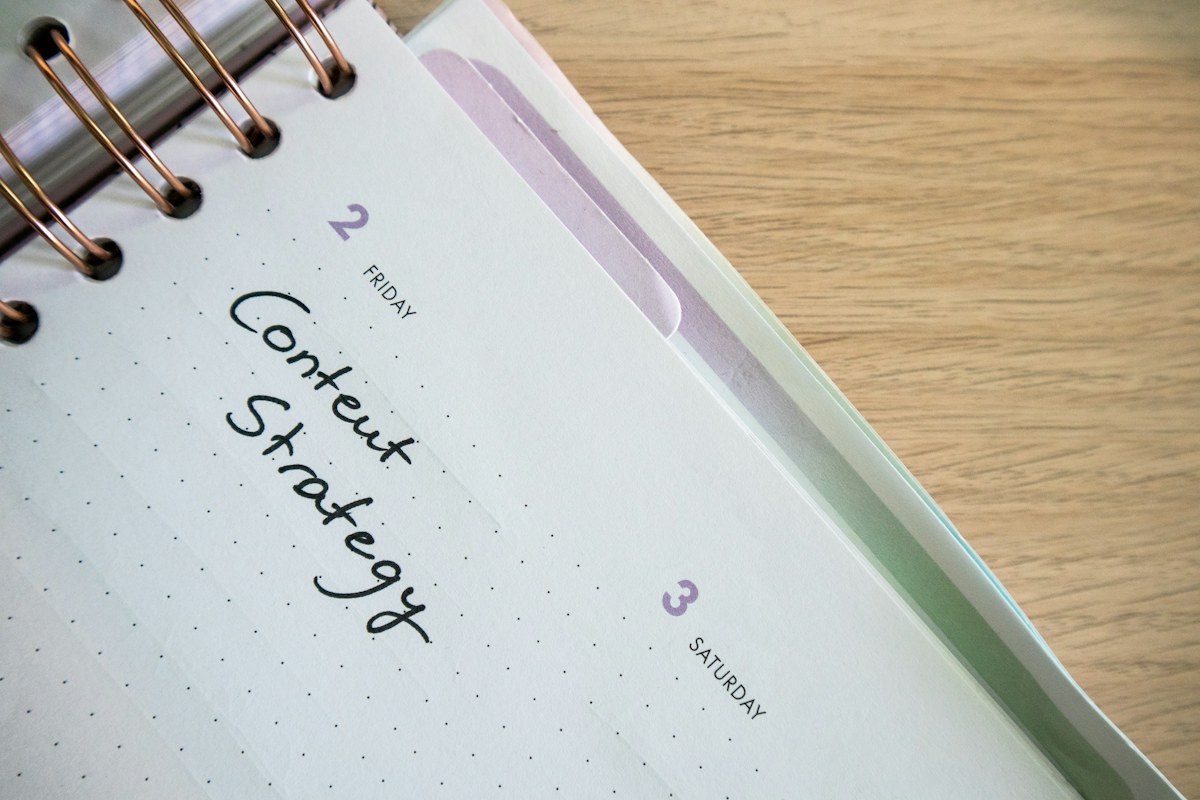 A spiral planner with a small notepad and pen
